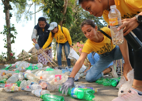 A group of people picking up recyclables